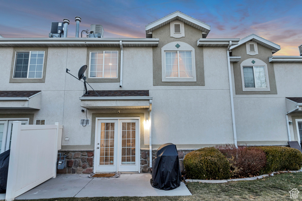 Rear view of property with stucco siding and a patio