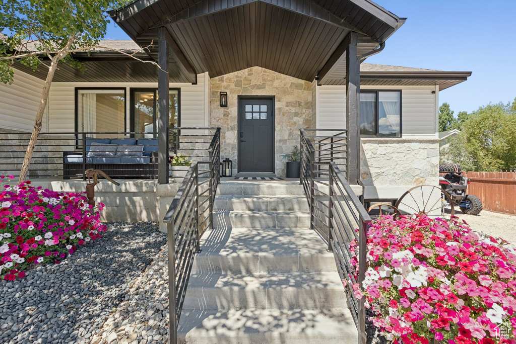 Entrance to property featuring stone siding and a porch