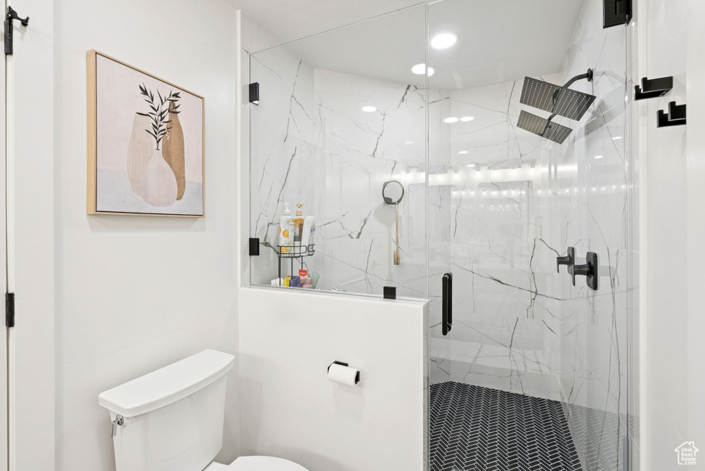 Full bath with a marble finish shower and recessed lighting