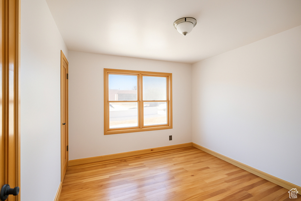 Unfurnished room with light wood finished floors and baseboards