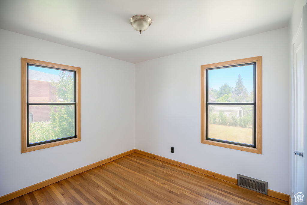 Spare room featuring baseboards and light wood finished floors