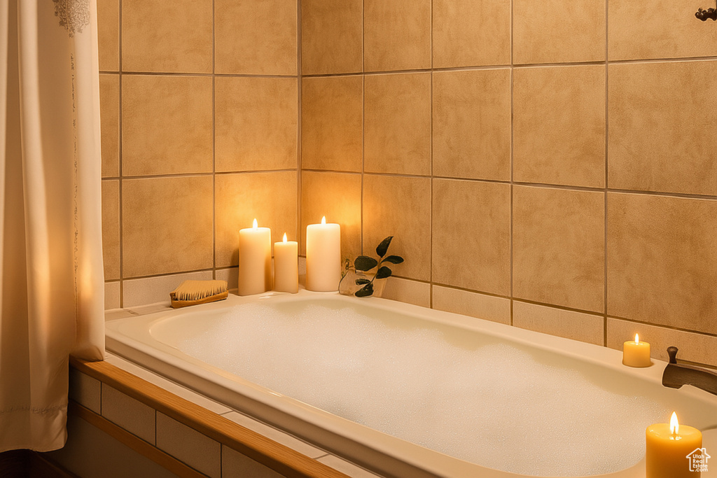 Full bath featuring tile walls and a bath