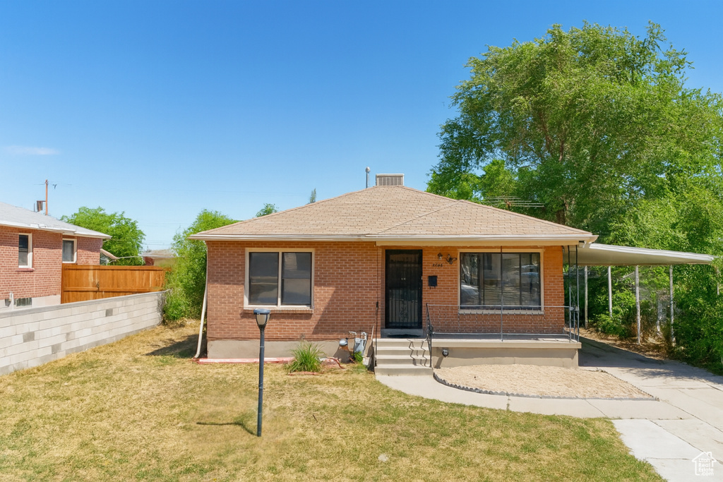 View of front of property featuring concrete driveway, an attached carport, a shingled roof, and brick siding