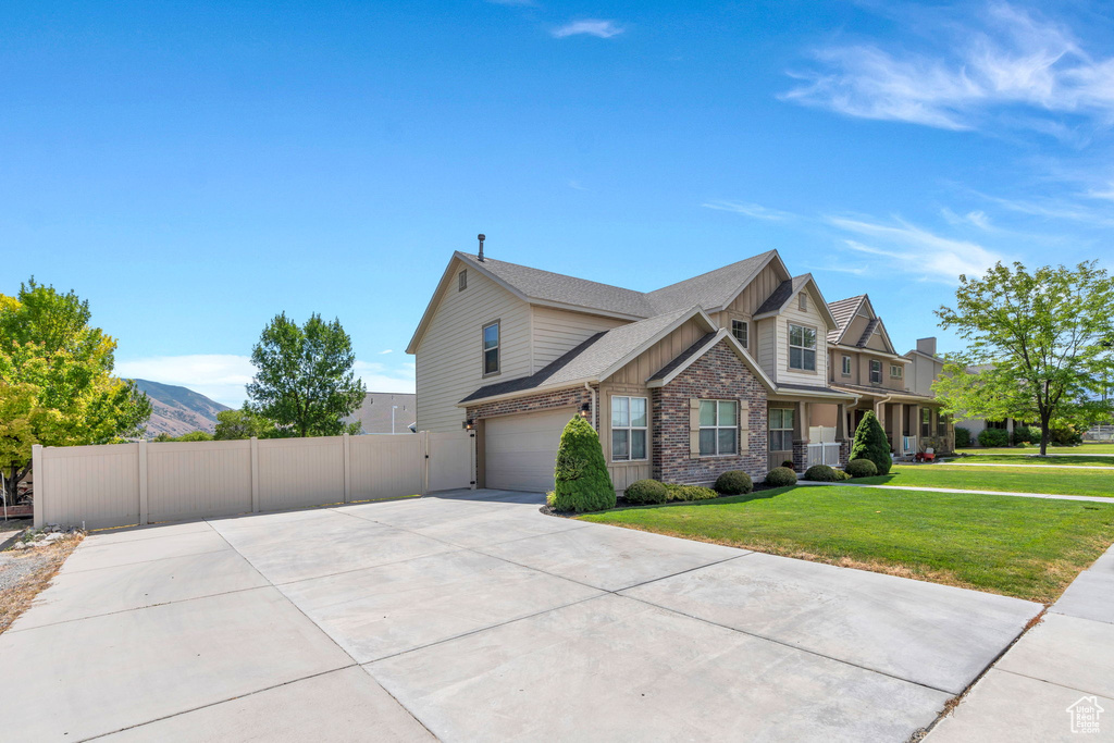 View of side of property featuring driveway, an attached garage, and brick siding