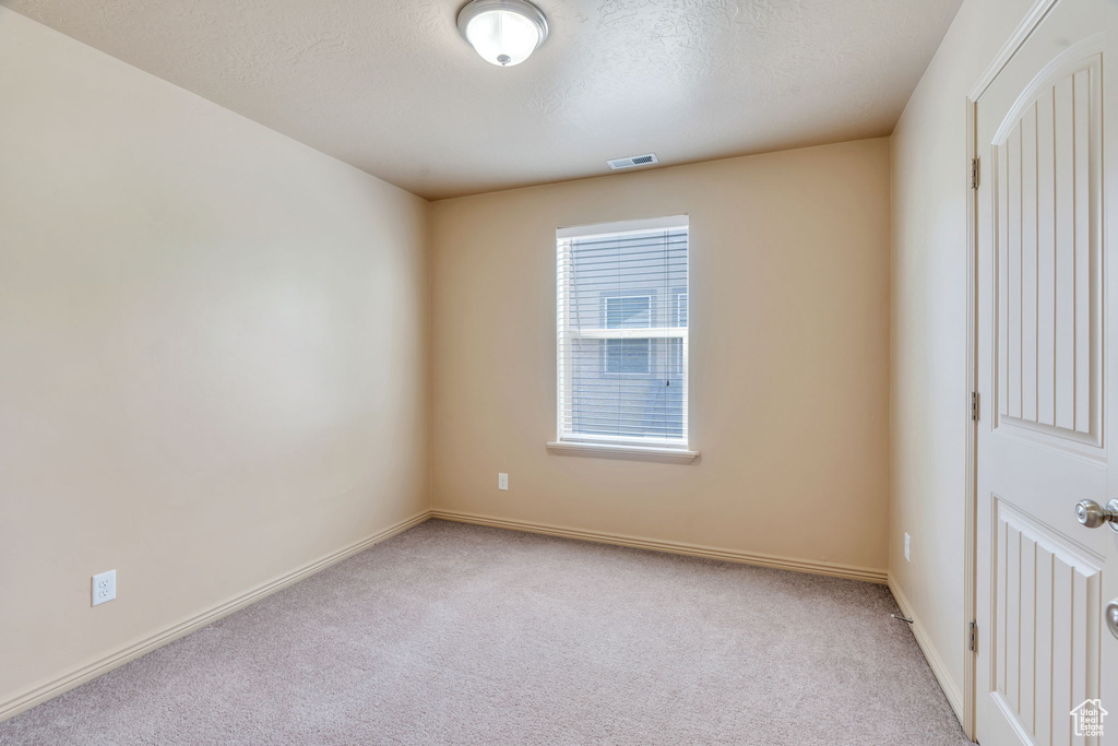 Carpeted empty room featuring baseboards