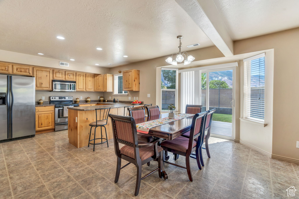 Dining space featuring a chandelier, recessed lighting, a textured ceiling, and beam ceiling