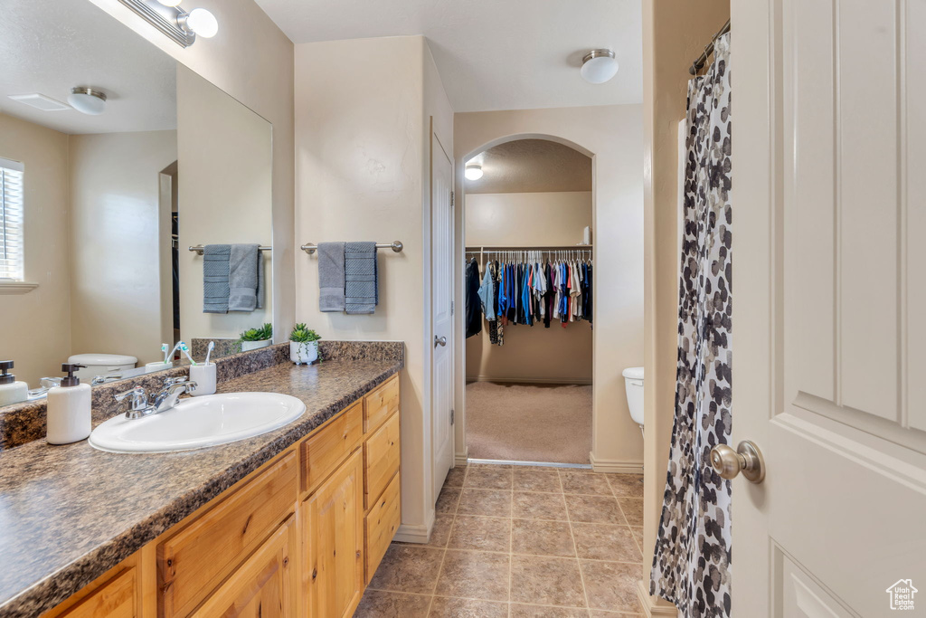 Bathroom with vanity, tile patterned floors, and a spacious closet