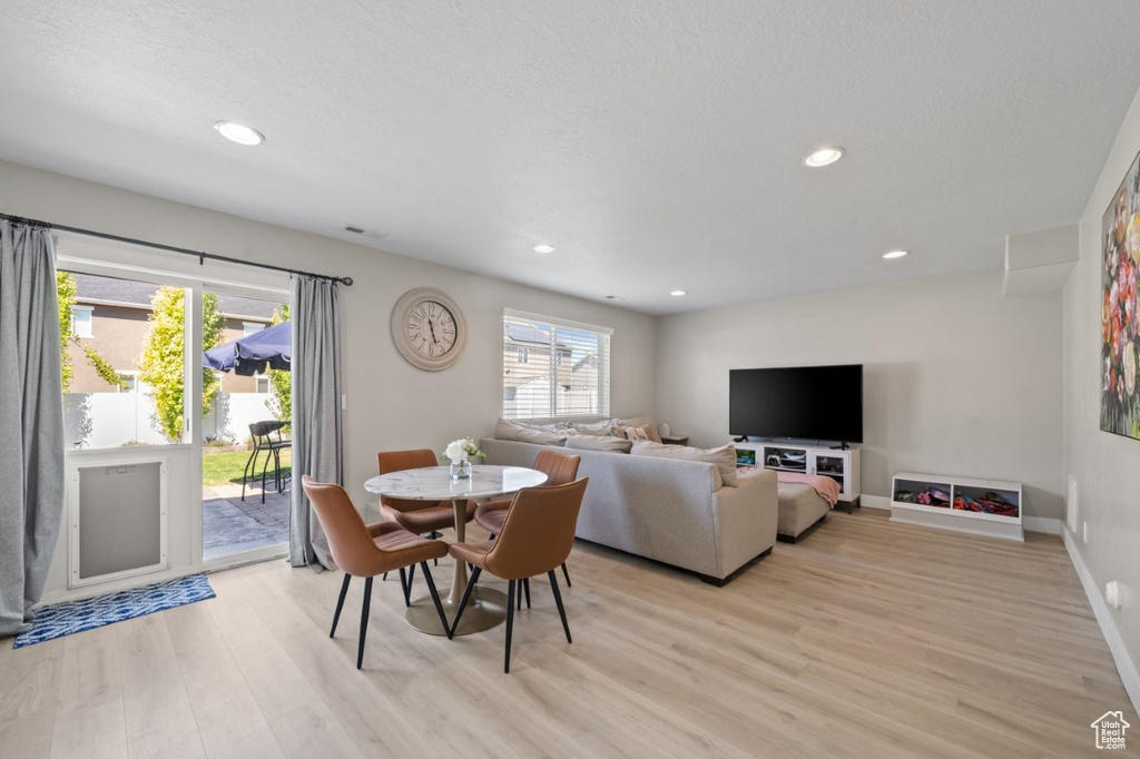 Dining space with light wood-type flooring and recessed lighting