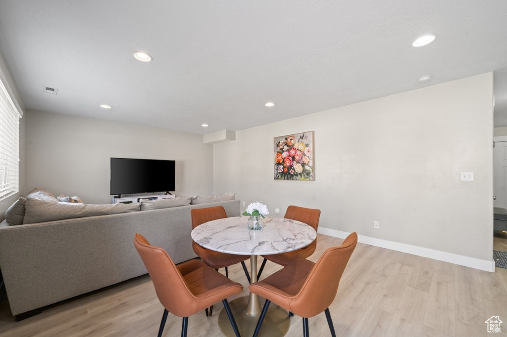 Dining area with light wood-type flooring and recessed lighting