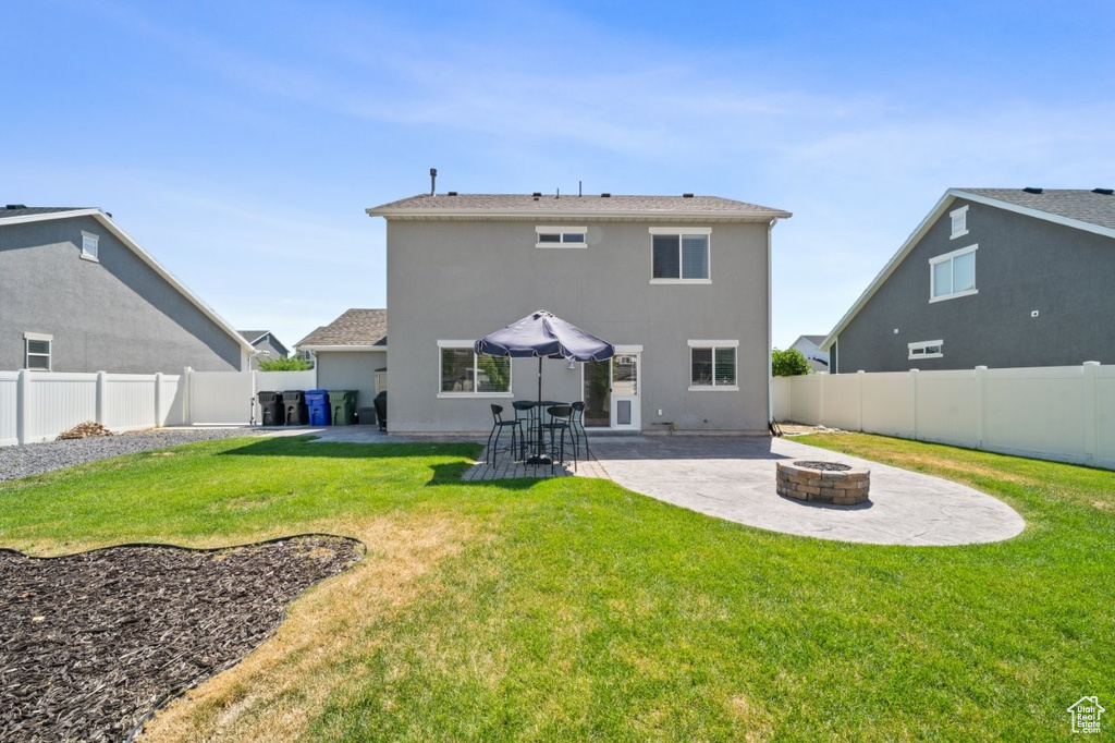 Back of house featuring an outdoor fire pit, a patio area, a fenced backyard, and stucco siding