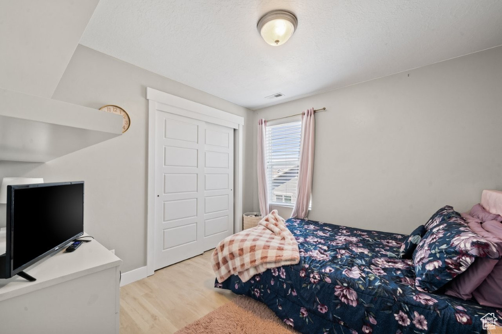 Bedroom featuring wood finished floors and a closet
