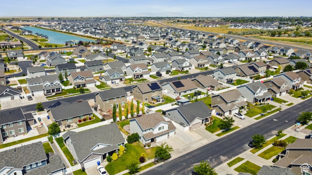 Aerial view of property and surrounding area featuring a nearby body of water and nearby suburban area