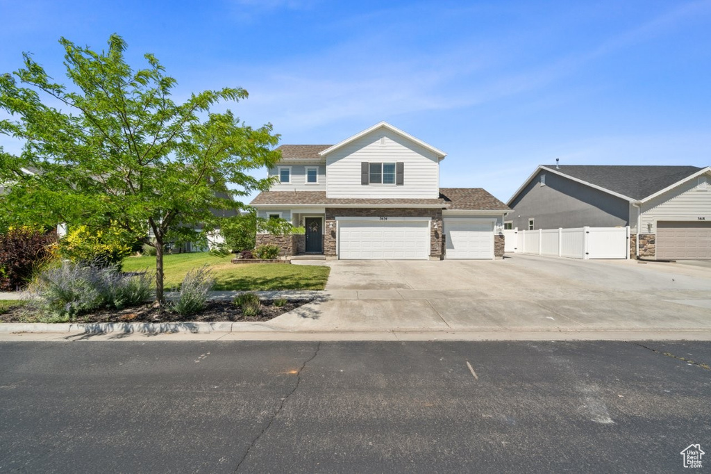 View of front of home with driveway and a garage