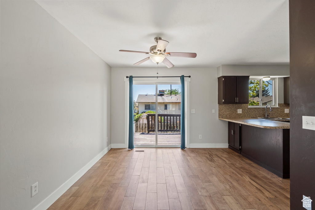 Kitchen with plenty of natural light, ceiling fan, light wood-style floors, and tasteful backsplash