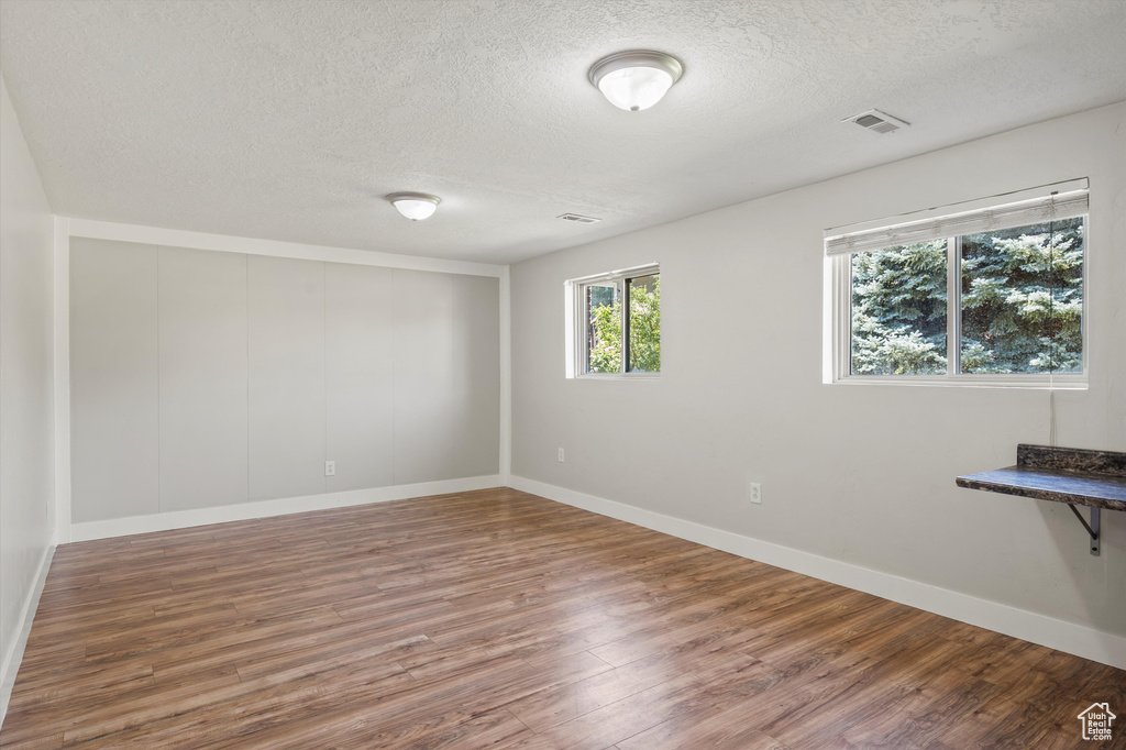 Unfurnished room featuring a textured ceiling and wood finished floors