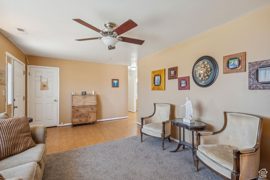 Living area featuring ceiling fan and carpet floors