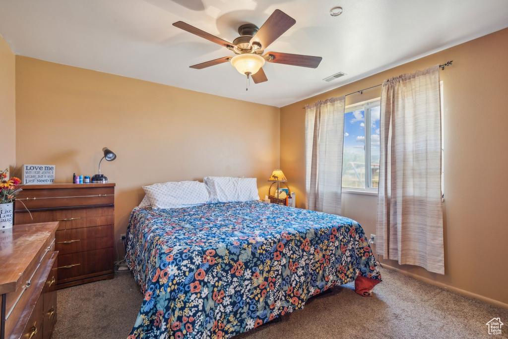 Carpeted bedroom featuring a ceiling fan