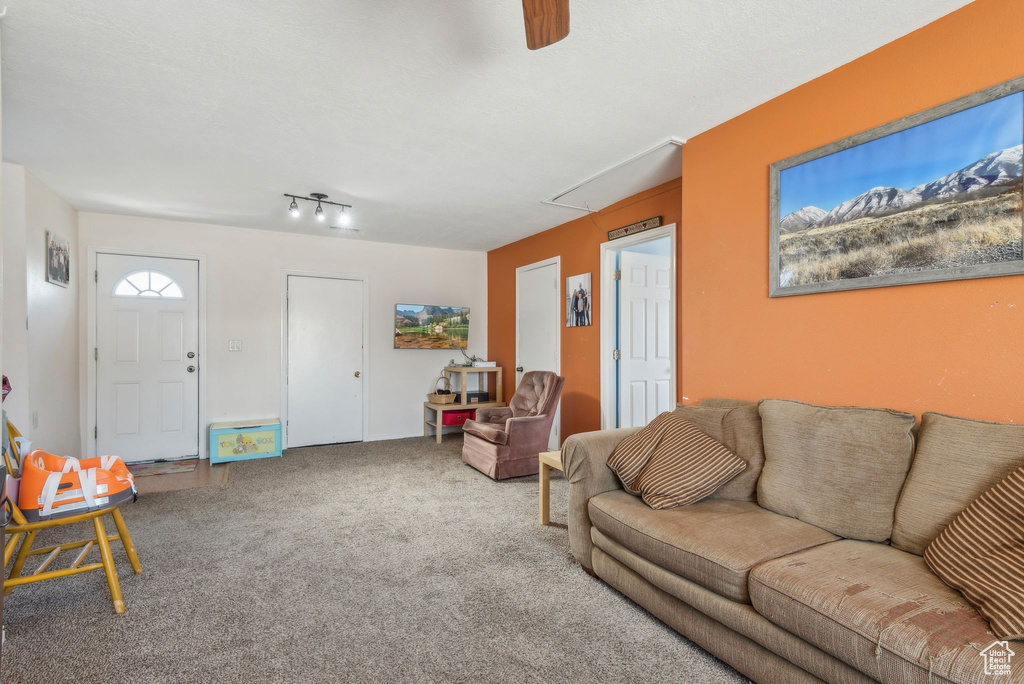 Living room with attic access, carpet, and ceiling fan