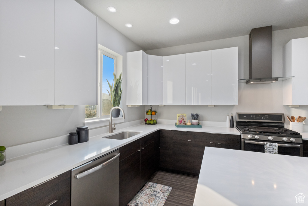 Kitchen with stainless steel appliances, wall chimney range hood, modern cabinets, and recessed lighting