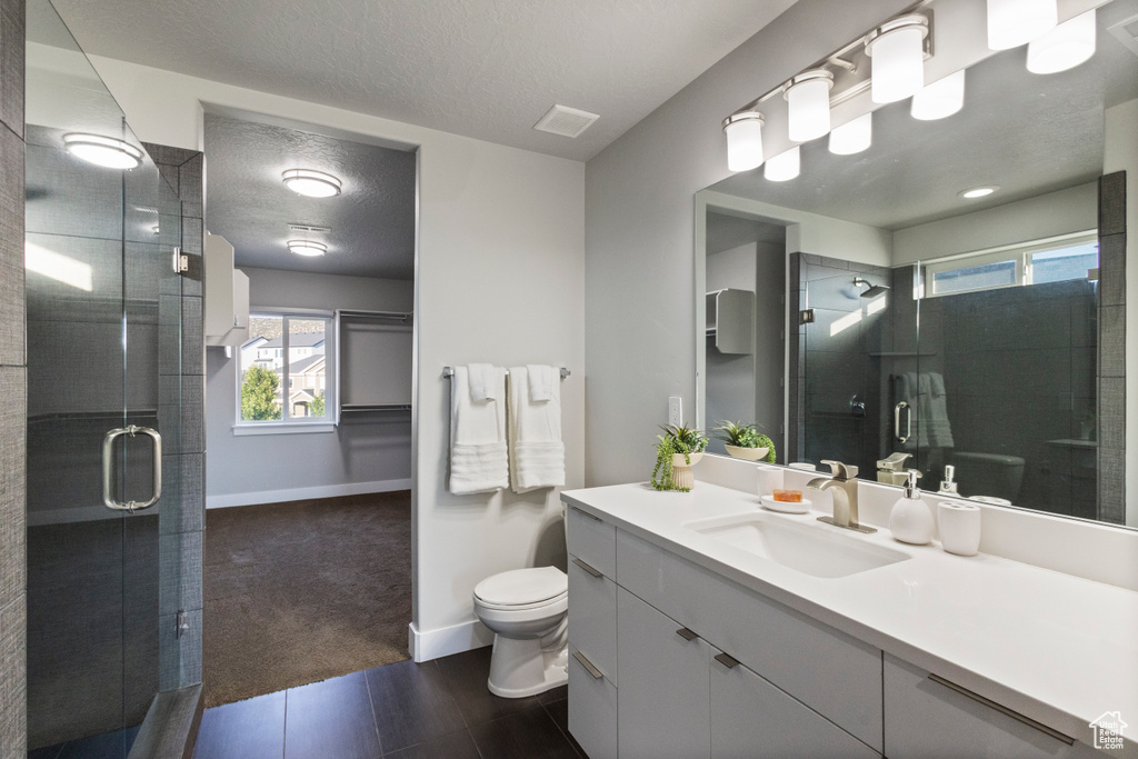 Bathroom featuring vanity, a textured ceiling, and a shower stall