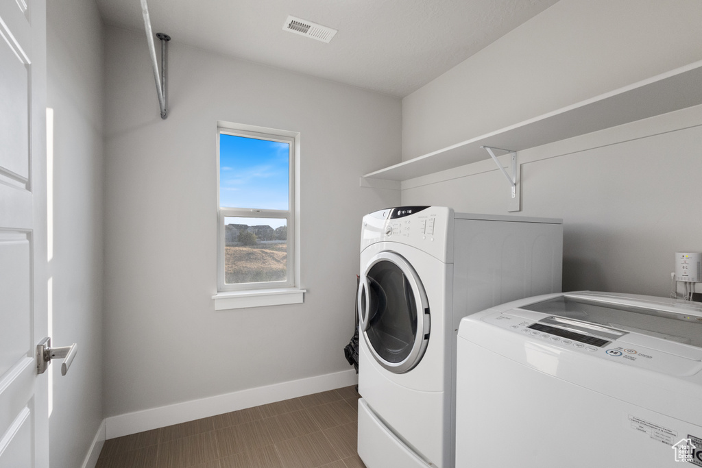 Laundry room featuring washer and clothes dryer and baseboards