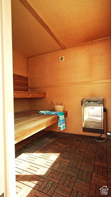 Sauna / steam room with brick flooring and wooden walls