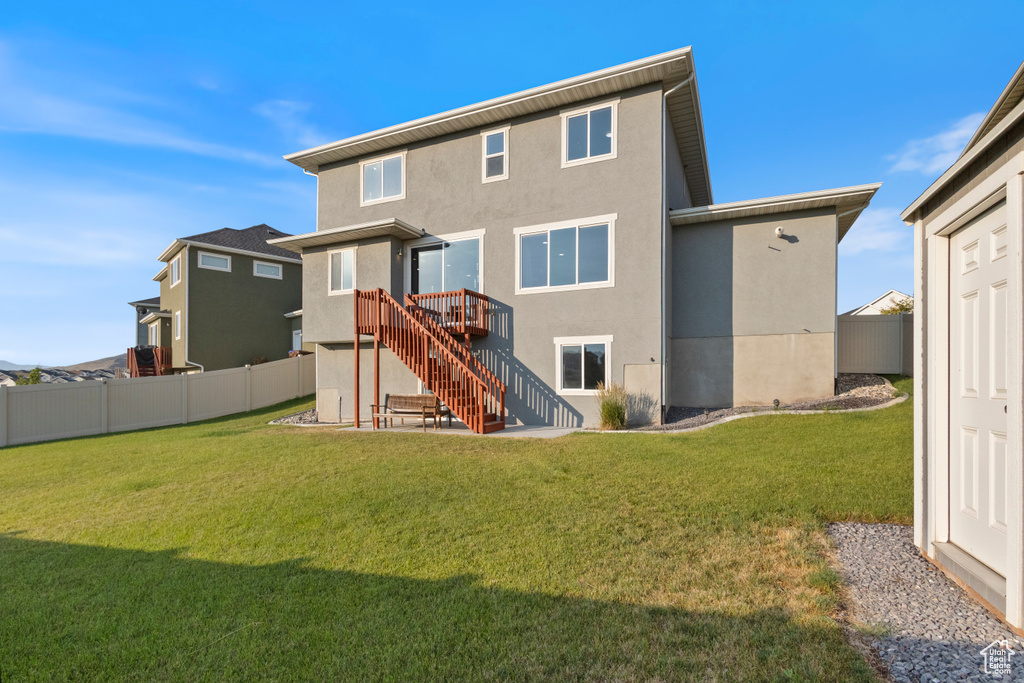 Rear view of house featuring stucco siding and stairs