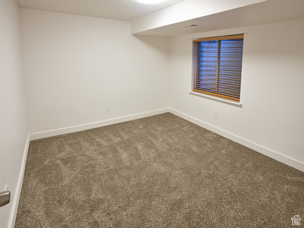 Unfurnished room featuring carpet floors and baseboards