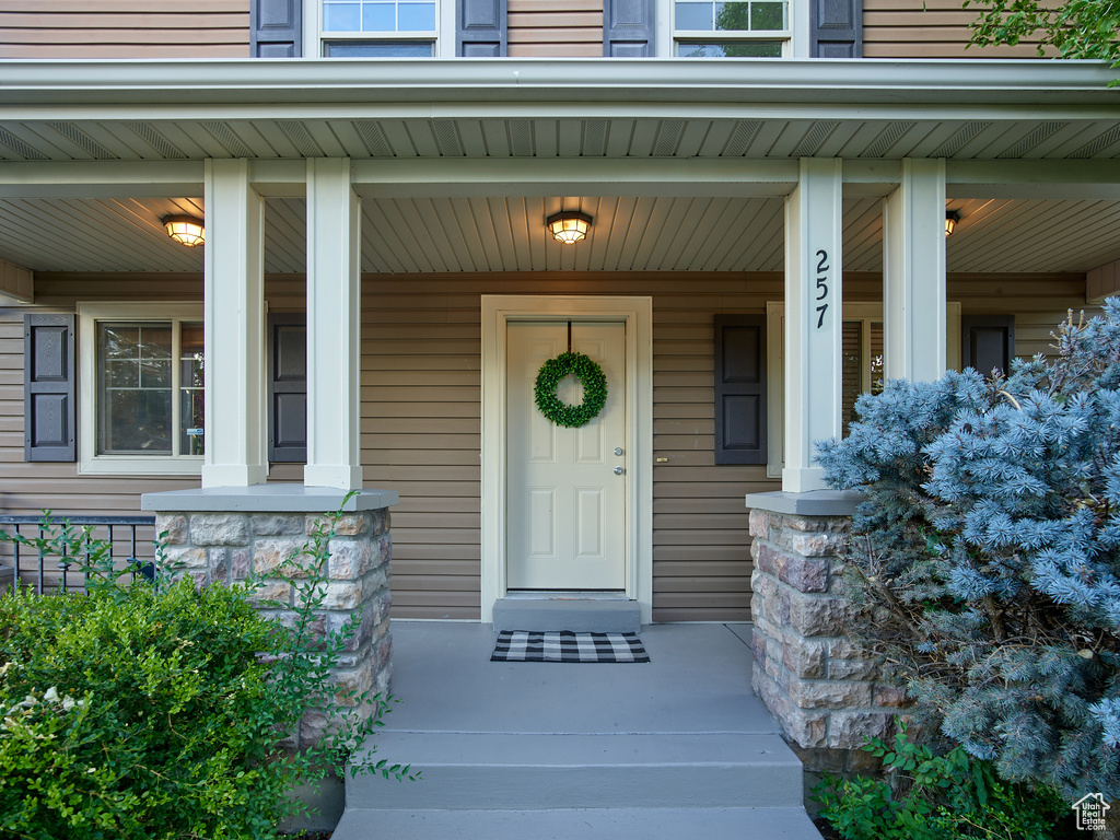 Entrance to property featuring covered porch and stone siding