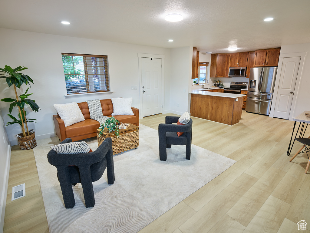 Living area featuring light wood-style floors and recessed lighting
