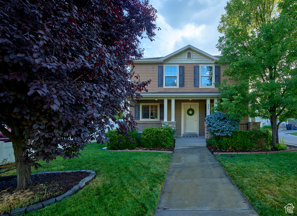 Traditional-style home featuring a front yard and a porch