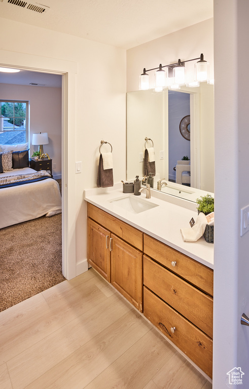 Ensuite bathroom with vanity and wood finished floors