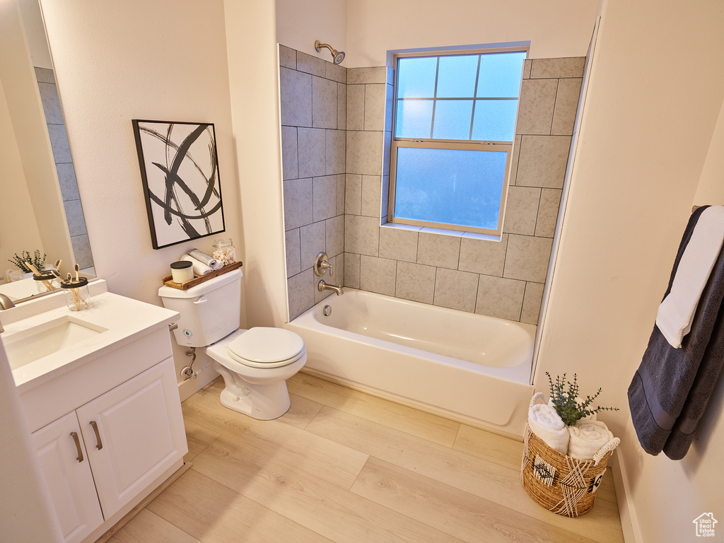 Full bath with vanity,  shower combination, and wood finished floors