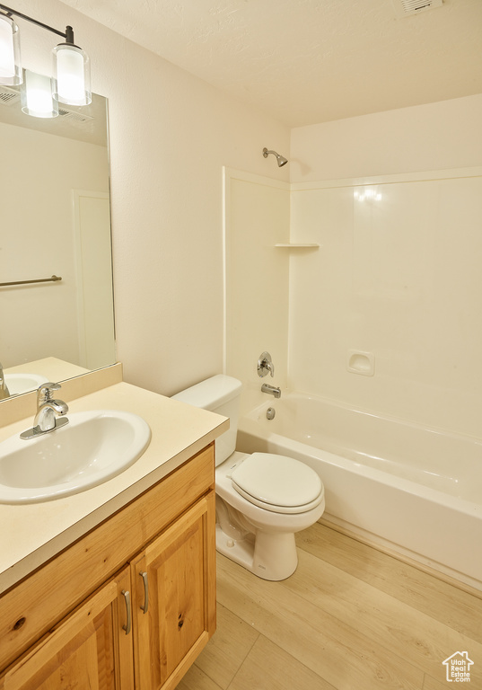 Full bath with vanity, shower / washtub combination, and wood finished floors
