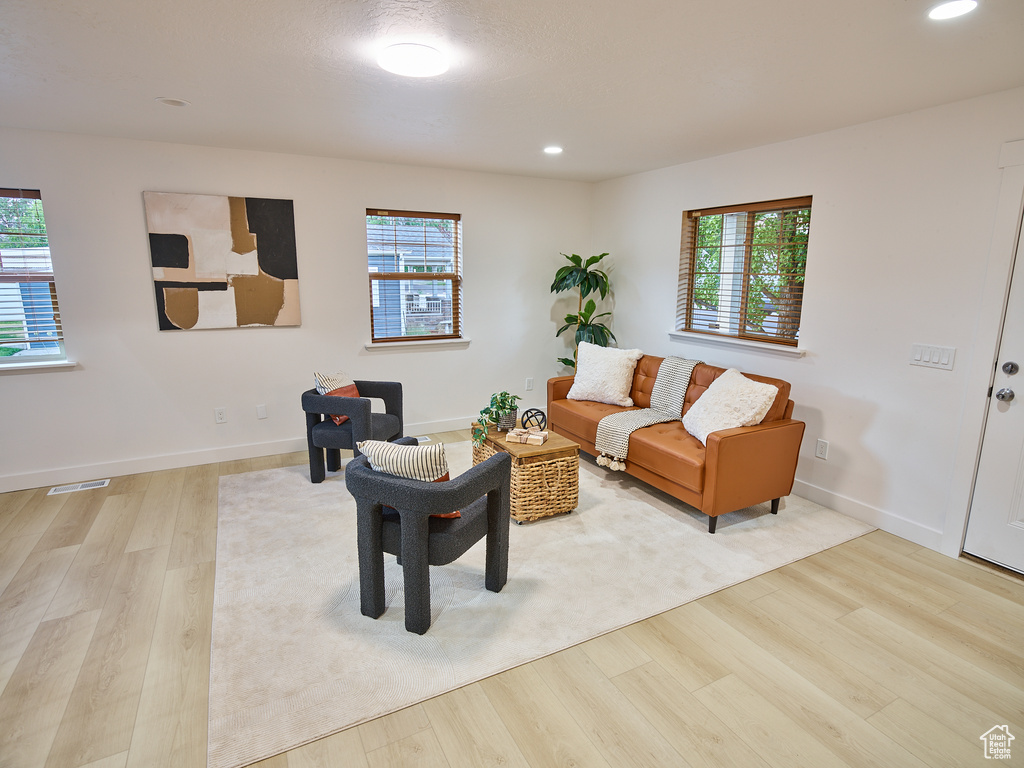 Living area with wood finished floors and recessed lighting