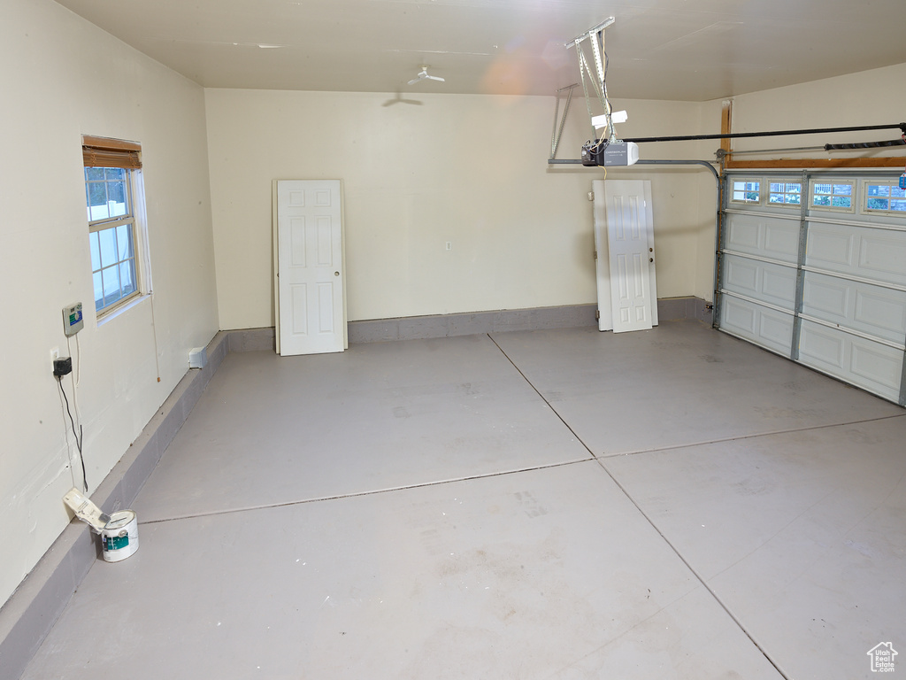 Garage featuring a garage door opener and baseboards
