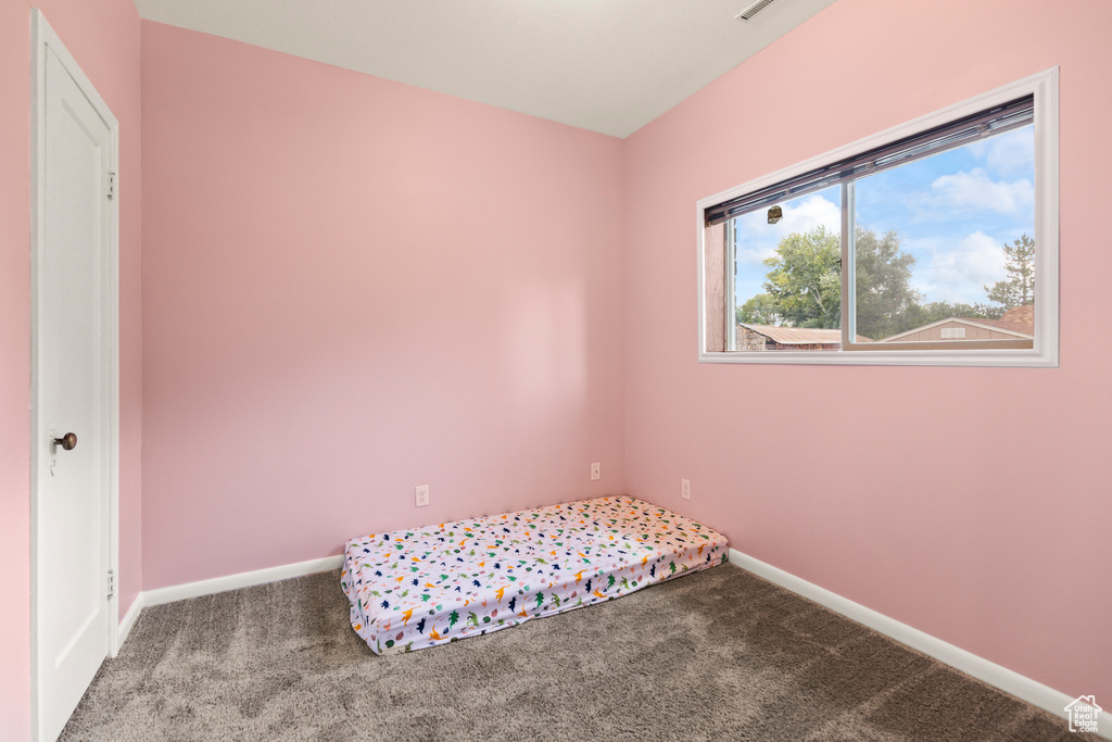 Unfurnished bedroom with carpet flooring and baseboards
