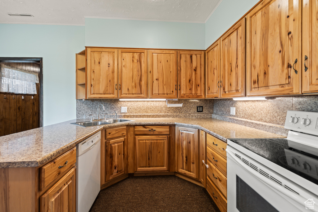 Kitchen featuring white appliances, crown molding, backsplash, open shelves, and a peninsula