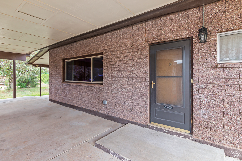 View of exterior entry with a patio area