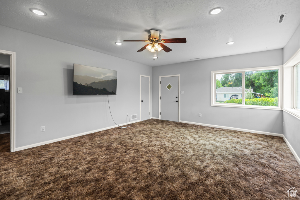 Unfurnished living room featuring carpet, ceiling fan, recessed lighting, and a textured ceiling