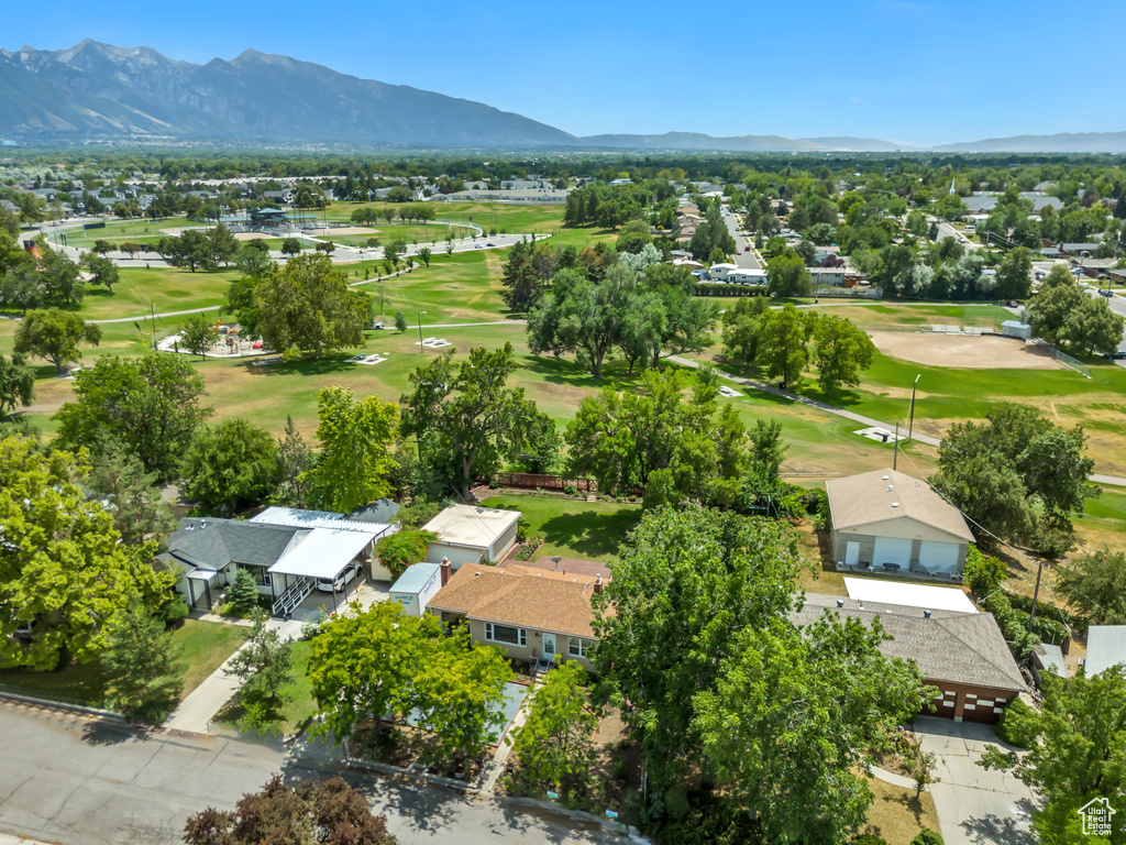 Aerial perspective of suburban area featuring a local golf course and a mountainous background
