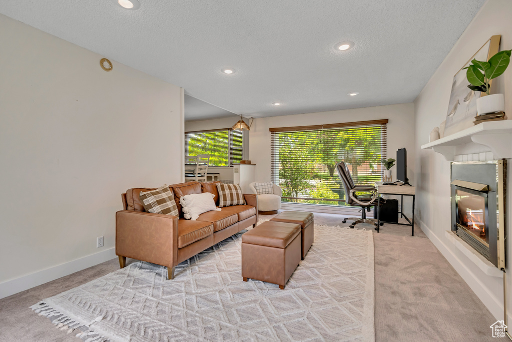 Living room with carpet floors, a textured ceiling, a desk, and recessed lighting