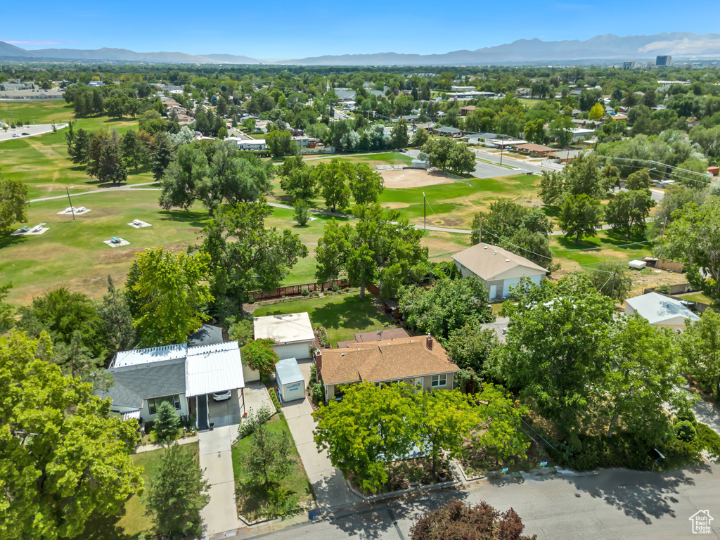 Aerial perspective of suburban area featuring a mountain backdrop and a local golf course