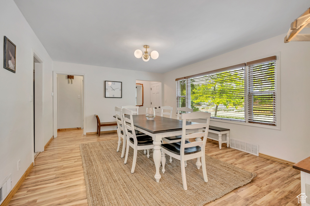 Dining area featuring light wood-style floors and a chandelier