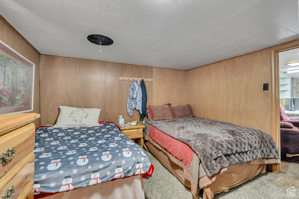 Bedroom with carpet flooring and wood walls