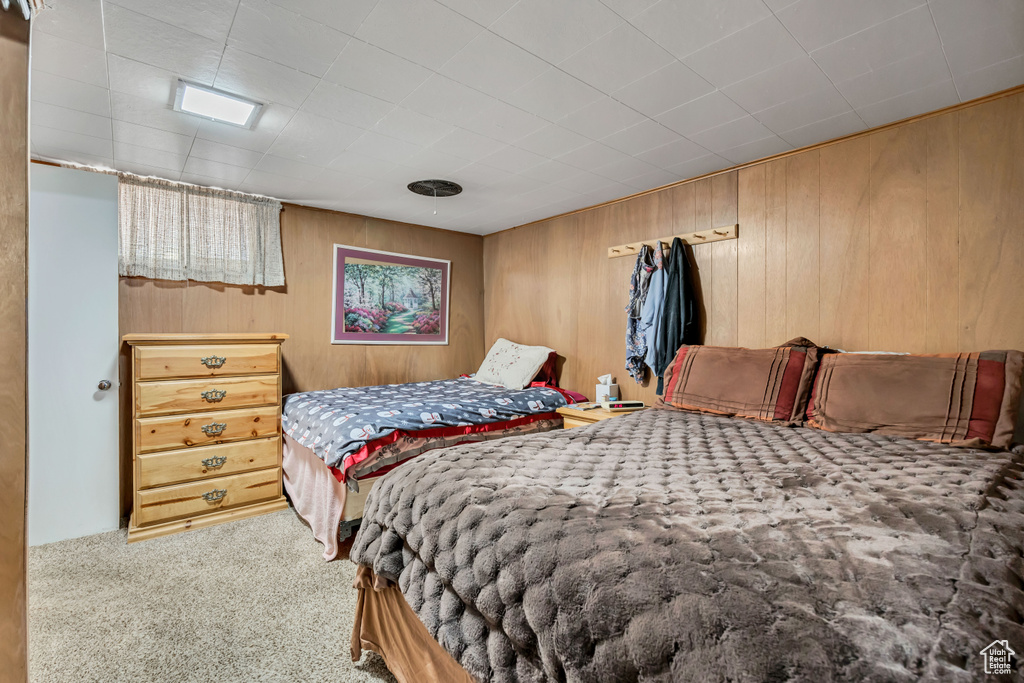 Bedroom featuring carpet and wooden walls