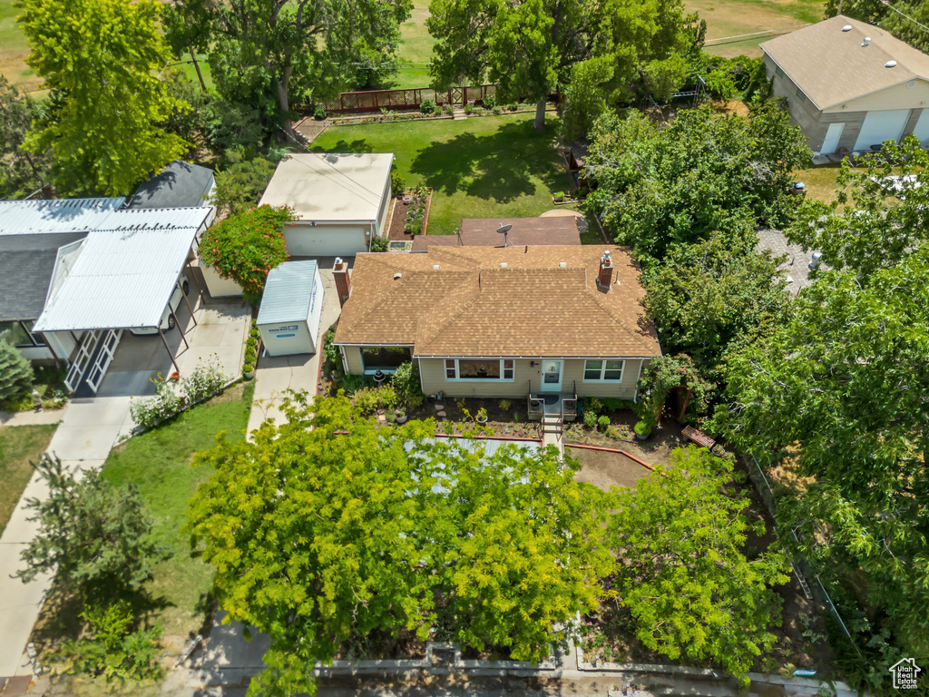 Aerial view of property and surrounding area with a tree filled landscape