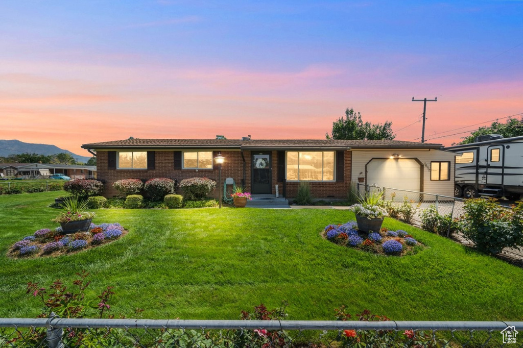 Ranch-style home featuring an attached garage, brick siding, and a mountain view
