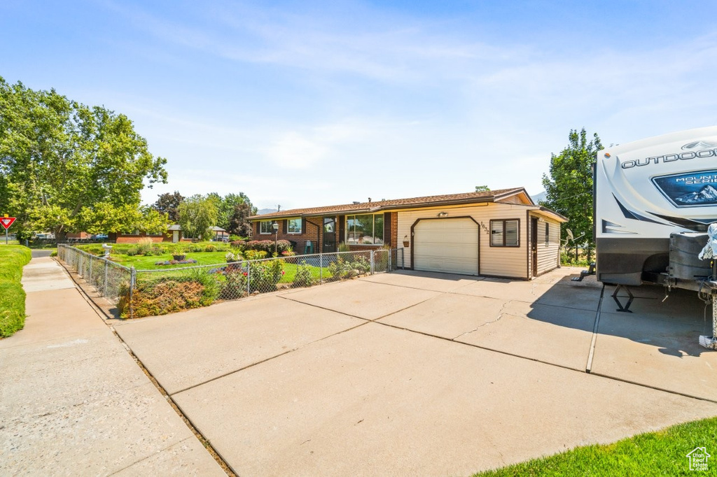 View of front of property with concrete driveway and a garage
