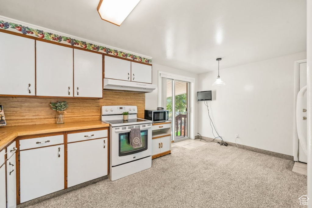 Kitchen featuring white electric range oven, under cabinet range hood, light countertops, white cabinets, and decorative light fixtures